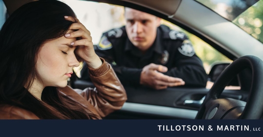 woman upset in car being talked to by police officer