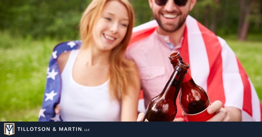 couple celebrating Memorial Day and holding beer bottles